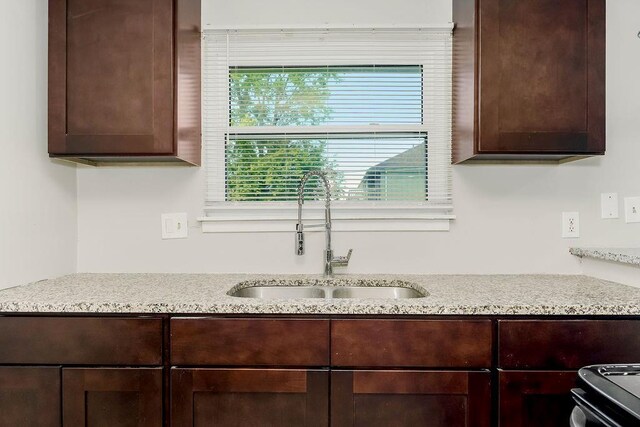 1924 N 75th Dr, Kansas City, KS 66112 - detailed view of a sink, dark brown cabinetry, electric range, and light stone counters