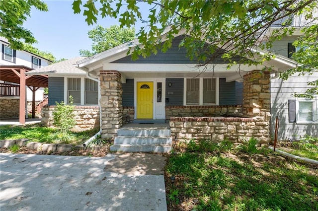 view of front of house featuring stone siding and a porch