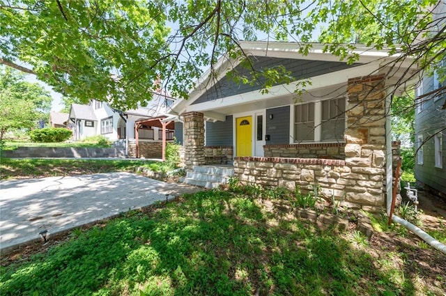 view of front of home with a porch and stone siding