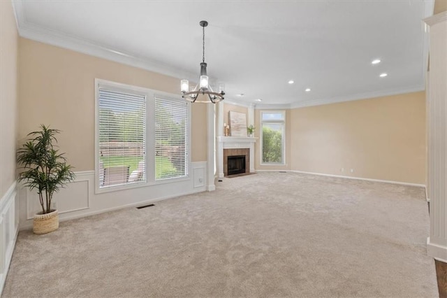 unfurnished living room featuring ornamental molding, carpet, a chandelier, a wainscoted wall, and recessed lighting