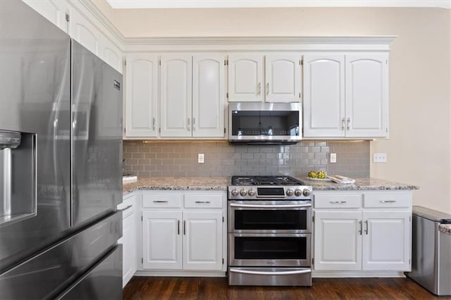 kitchen featuring appliances with stainless steel finishes, dark wood finished floors, backsplash, and white cabinets