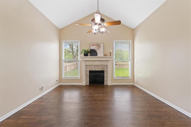 unfurnished living room featuring dark wood-style flooring, a fireplace, healthy amount of natural light, a ceiling fan, and vaulted ceiling