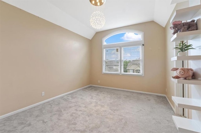 carpeted spare room with vaulted ceiling and baseboards