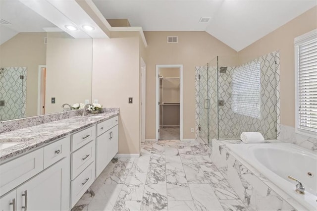 bathroom with a shower stall, vaulted ceiling, marble finish flooring, a garden tub, and double vanity