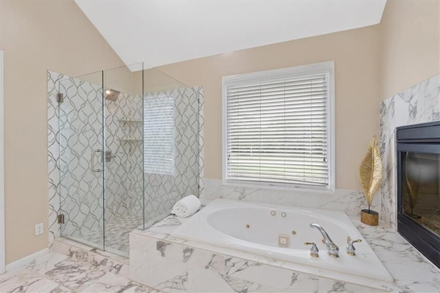 full bathroom with a stall shower, a whirlpool tub, a fireplace, lofted ceiling, and marble finish flooring