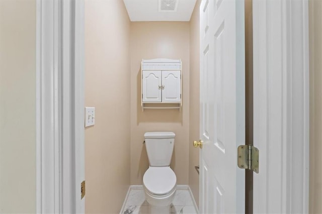 bathroom featuring baseboards, toilet, and tile patterned floors