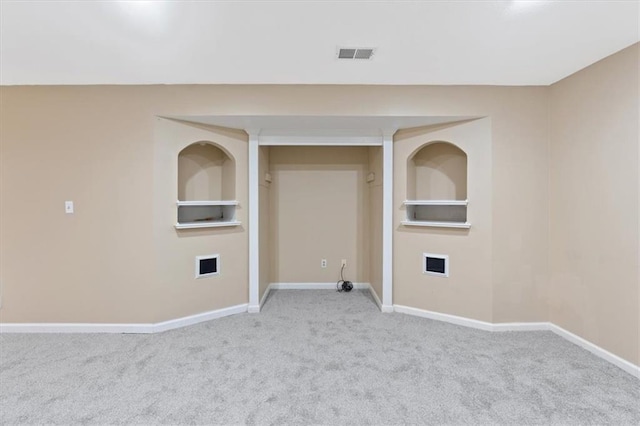 spare room featuring carpet flooring, baseboards, and built in shelves