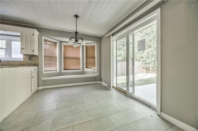 529 SW Windmill Ln, Lees Summit, MO 64082 - unfurnished dining area with a chandelier, baseboards, and light tile patterned floors