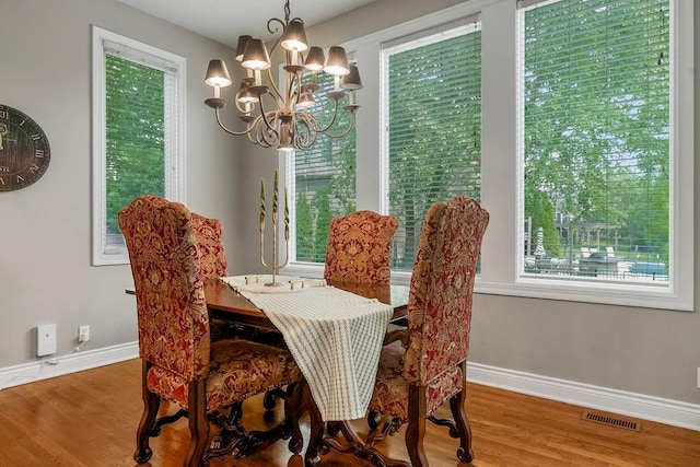 6104 W 144th St, Overland Park, KS 66223 - dining area featuring a chandelier, wood finished floors, healthy amount of natural light, and baseboards