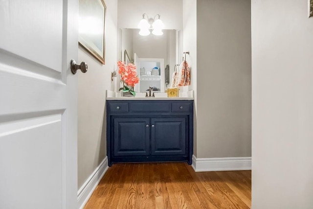 6104 W 144th St, Overland Park, KS 66223 - bathroom with wood finished floors, vanity, baseboards, and a chandelier
