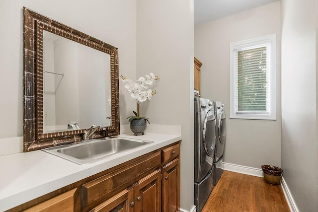 6104 W 144th St, Overland Park, KS 66223 - washroom with washing machine and dryer, cabinet space, baseboards, and wood finished floors