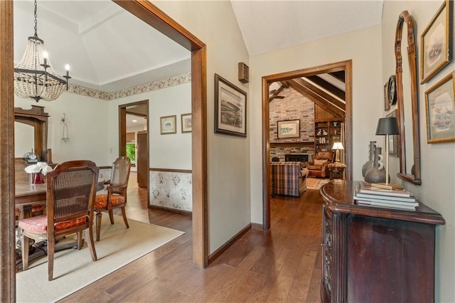 20129 W 112th Cir, Olathe, KS 66061 - hallway with vaulted ceiling, a chandelier, and dark wood finished floors
