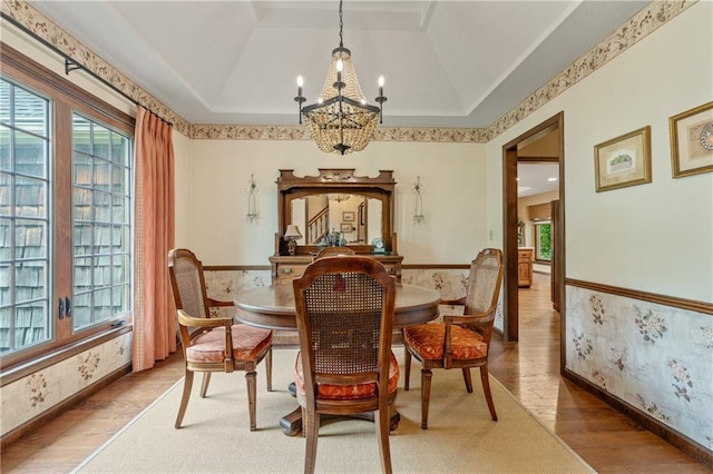 20129 W 112th Cir, Olathe, KS 66061 - dining space featuring a chandelier, wood finished floors, plenty of natural light, a raised ceiling, and wallpapered walls