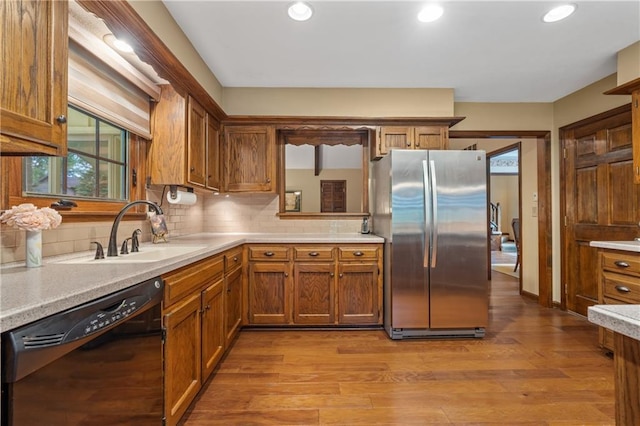20129 W 112th Cir, Olathe, KS 66061 - kitchen with freestanding refrigerator, black dishwasher, a sink, brown cabinetry, and light countertops
