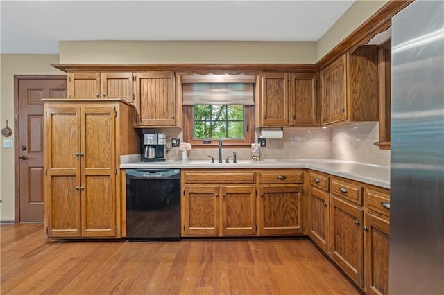 20129 W 112th Cir, Olathe, KS 66061 - kitchen with black dishwasher, stainless steel refrigerator, a sink, and light wood-style flooring