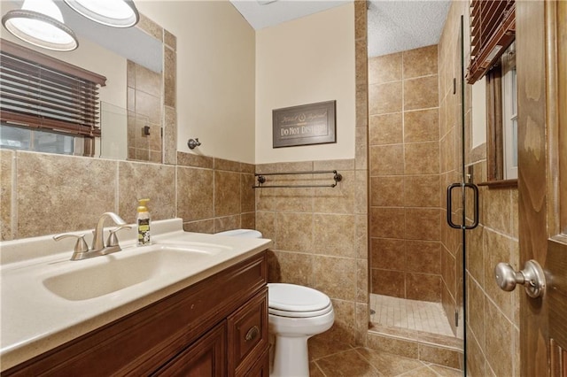 20129 W 112th Cir, Olathe, KS 66061 - bathroom with tile walls, toilet, a shower stall, vanity, and tile patterned flooring