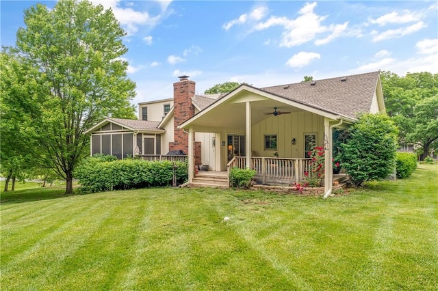 20129 W 112th Cir, Olathe, KS 66061 - back of house featuring a sunroom, board and batten siding, a shingled roof, and a lawn