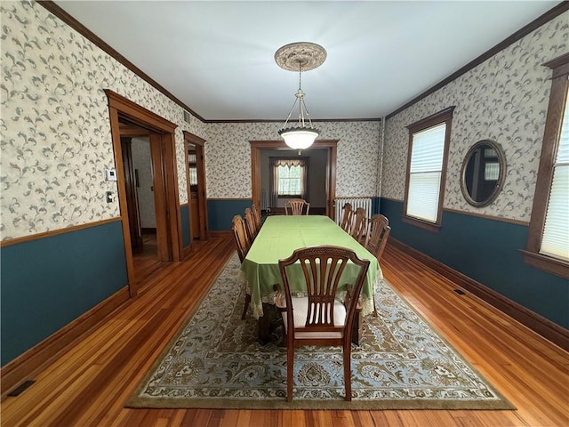 1701 Main St, Lexington, MO 64067 - dining area featuring ornamental molding, a wainscoted wall, wallpapered walls, and wood finished floors
