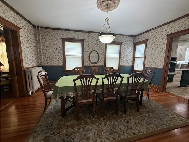 1701 Main St, Lexington, MO 64067 - dining space featuring radiator heating unit, a wainscoted wall, crown molding, wood-type flooring, and healthy amount of natural light