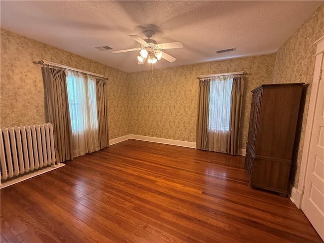 1701 Main St, Lexington, MO 64067 - spare room featuring radiator, hardwood / wood-style flooring, ceiling fan, and a textured ceiling