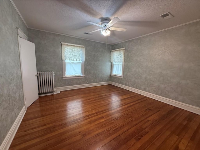 1701 Main St, Lexington, MO 64067 - empty room featuring radiator heating unit, wood finished floors, a ceiling fan, crown molding, and a textured ceiling