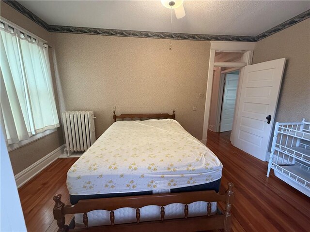 1701 Main St, Lexington, MO 64067 - bedroom featuring radiator, wood finished floors, and a ceiling fan