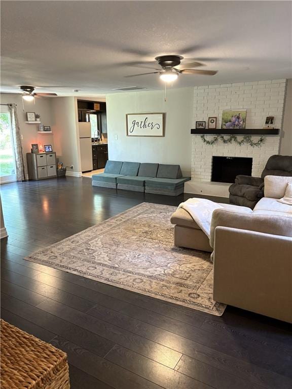 509 Pearl St, Pittsburg, KS 66762 - living area with a ceiling fan, wood-type flooring, and a brick fireplace