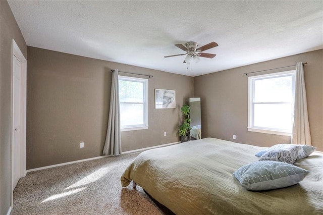 carpeted bedroom with baseboards, a textured ceiling, and a ceiling fan