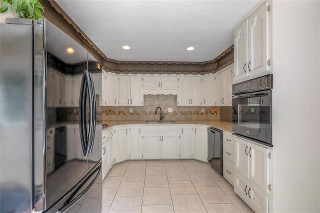 kitchen featuring black appliances, a sink, light tile patterned floors, white cabinetry, and recessed lighting