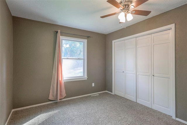 unfurnished bedroom with carpet floors, a closet, baseboards, and ceiling fan