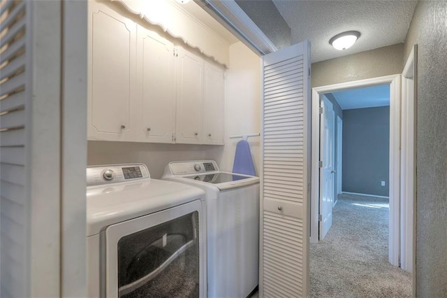 laundry area with cabinet space, independent washer and dryer, carpet flooring, and a textured ceiling