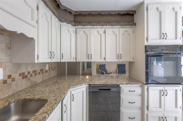 kitchen featuring black appliances, white cabinetry, light stone countertops, decorative backsplash, and a textured ceiling