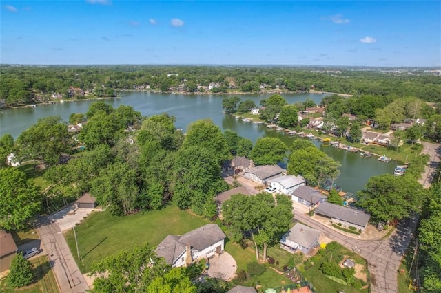 aerial overview of property's location with a nearby body of water, a heavily wooded area, and nearby suburban area