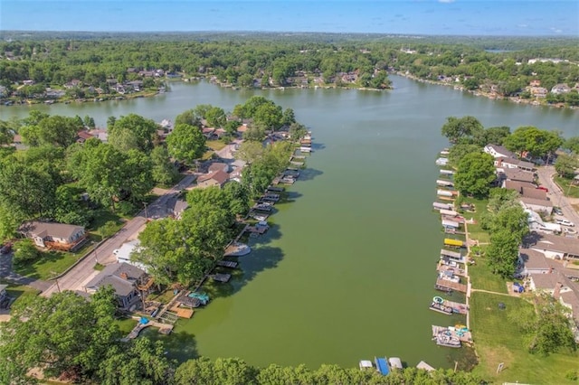 aerial overview of property's location featuring a nearby body of water, a forest, and nearby suburban area