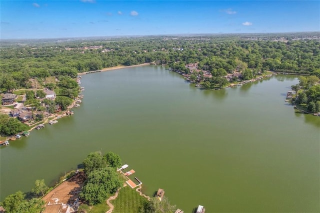 drone / aerial view of a heavily wooded area and a nearby body of water