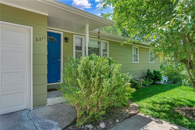 doorway to property featuring a lawn