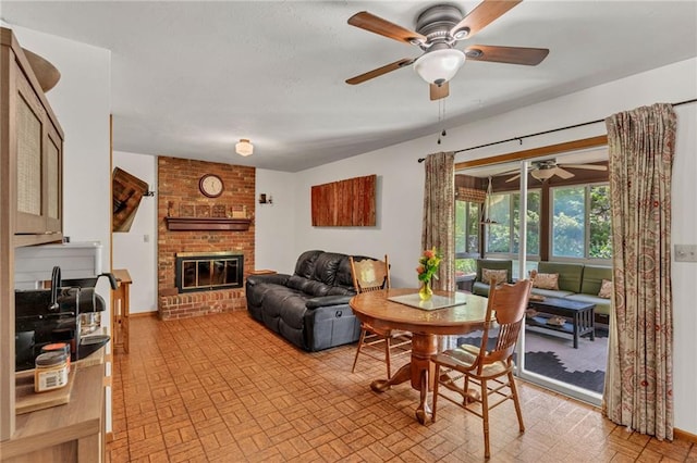 dining area with ceiling fan, brick patterned flooring, and a fireplace