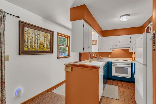 kitchen with white appliances, a sink, brick patterned flooring, white cabinets, and light countertops