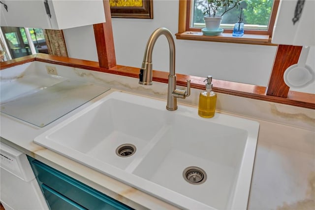 kitchen view of a sink and light countertops