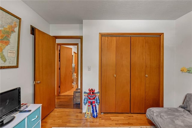 bedroom with light wood-type flooring and a closet