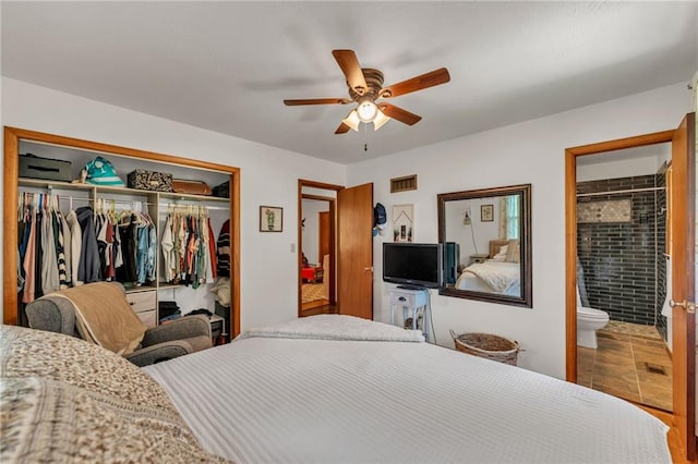 tiled bedroom featuring a closet, ensuite bathroom, and a ceiling fan