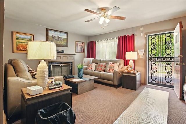 carpeted living room featuring a fireplace and a ceiling fan