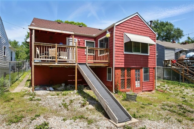 rear view of house featuring stairway, a deck, and fence