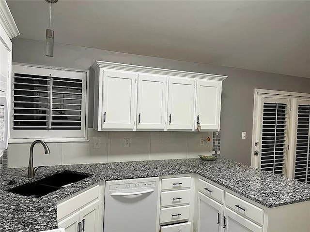 kitchen with dishwasher, a sink, white cabinets, a peninsula, and decorative backsplash