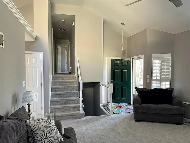 living room with high vaulted ceiling, carpet, and stairs
