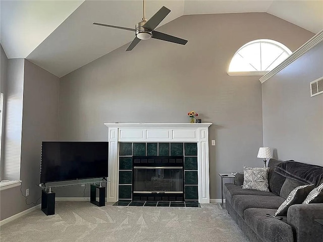 living area with a ceiling fan, carpet floors, high vaulted ceiling, baseboards, and a tile fireplace