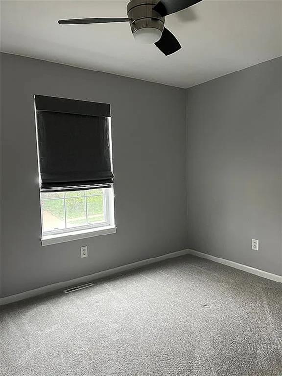 unfurnished room with a ceiling fan, carpet flooring, and baseboards