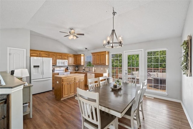 dining room with lofted ceiling, dark wood-type flooring, a textured ceiling, a chandelier, and ceiling fan