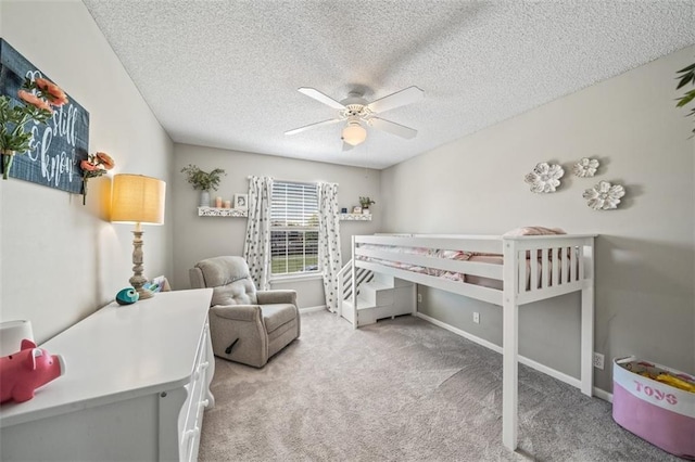 bedroom with carpet flooring, a textured ceiling, a ceiling fan, and baseboards