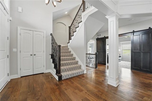 8833 N Crescent Ave, Kansas City, MO 64157 - foyer entrance featuring a barn door, stairs, wood finished floors, ornate columns, and recessed lighting